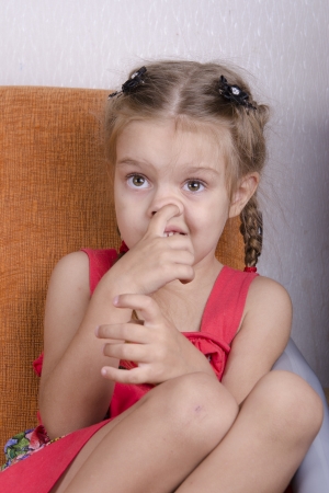 Girl sitting on the couch and picks his noseの写真素材