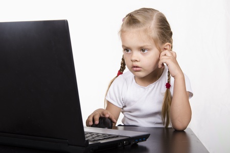 The girl sitting at the table and running laptopの写真素材