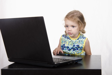 The girl sitting at the table and running laptopの写真素材