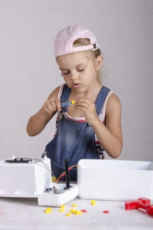 Girl tighten the screws to screw wrench, repairing toyの写真素材