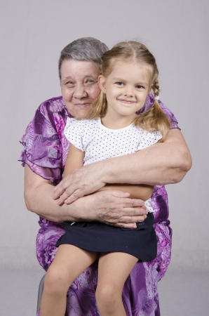 Portrait of an elderly woman covering her granddaughterの写真素材