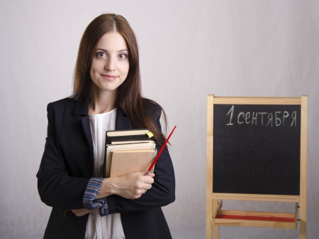 Portrait of the teacher with textbooks and Board in the backgroundの写真素材