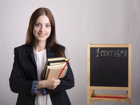Portrait of the teacher with textbooks and Board in the backgroundの写真素材