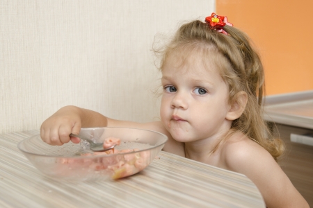 A child with a gloomy face eats porridgeの写真素材
