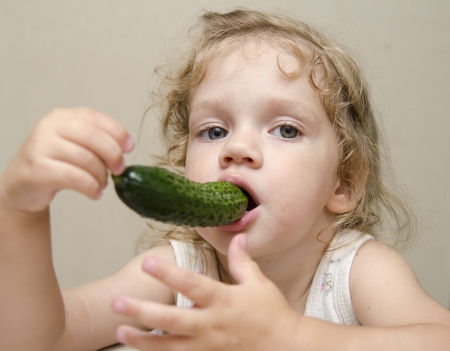 Girl funny eating cucumberの写真素材