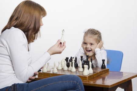 Mother explains daughter purpose of the chess piecesの写真素材