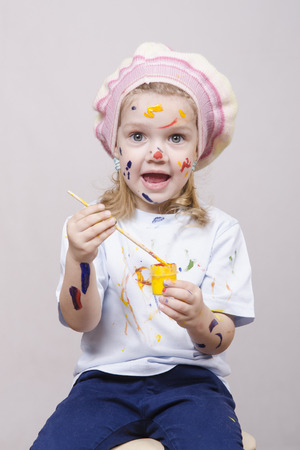 Portrait of a three-year old girl playing in the artist. Girl mud paintsの写真素材