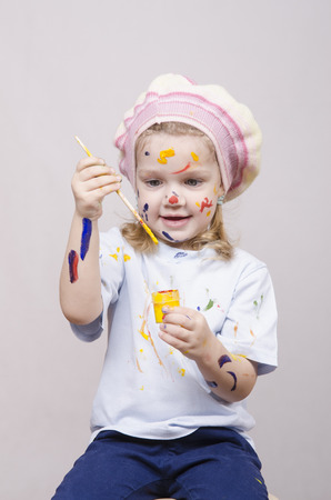 Portrait of a three-year old girl playing in the artist. Girl mud paintsの写真素材