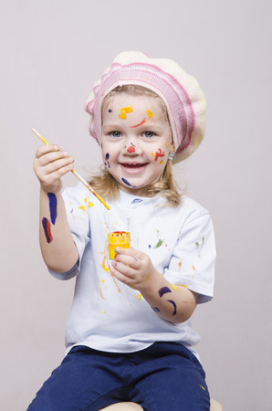 Portrait of a three-year old girl playing in the artist. Girl mud paintsの写真素材