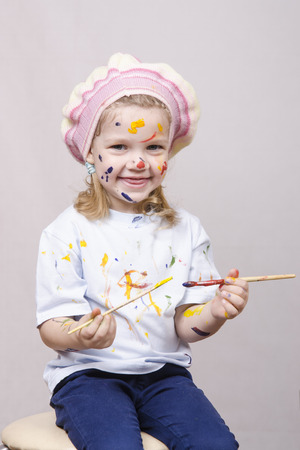 Portrait of a three-year old girl playing in the artist. Girl mud paintsの写真素材