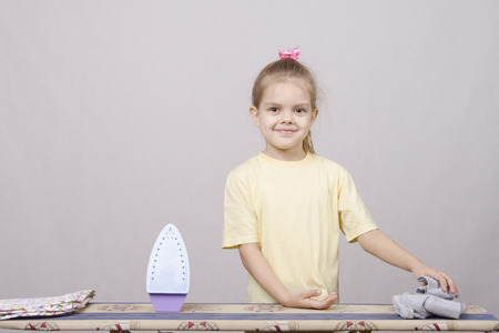 A five year old girl playing in a housewife, and stroking things ironの写真素材