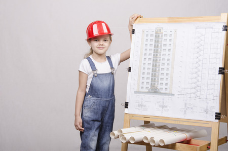 Girl Builder, architect, stands at the blackboard with the drawing of the buildingの写真素材