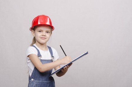 Girl engineer is a helmet folder and writes in folderの写真素材