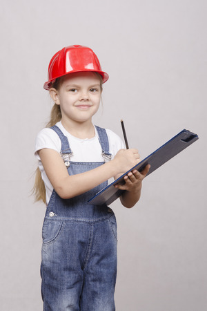 Girl engineer is a helmet folder and writes in folderの写真素材