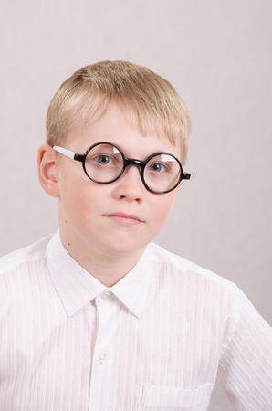 Twelve year old boy in glasses looking into the frameの写真素材