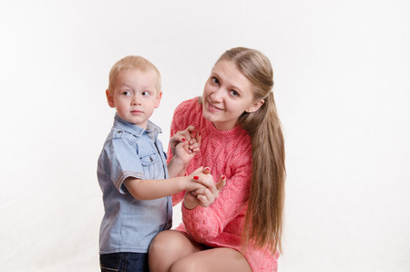 Young beautiful girl sitting on a chair with a three year old sonの写真素材