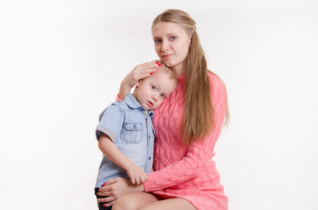 Young beautiful girl sitting on a chair with a three year old sonの写真素材