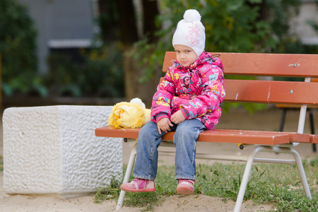 Girl three years walking on the Playground in cool autumn weatherの写真素材