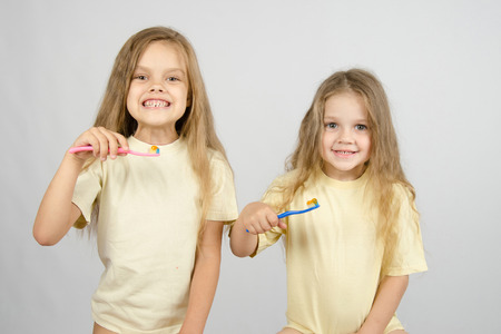 Two girls of four and six years of brushing their teeth toothbrushesの写真素材