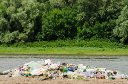A pile of garbage in the sand on the bank of the river in the background is a forestのeditorial素材