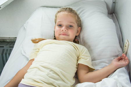 Four-year girl lies on a bed in a second-class train carriage