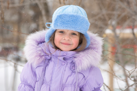 Portrait of a happy five year old girl in snowy winter weather