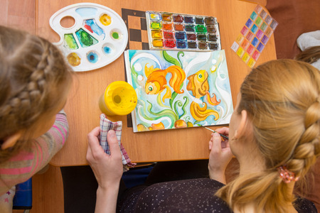 Teaching a child watercolor drawing top viewの写真素材