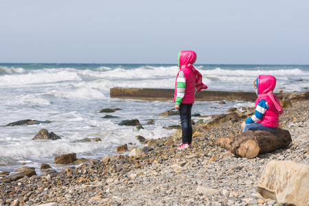 Two girls on the beach looking into the distanceの写真素材