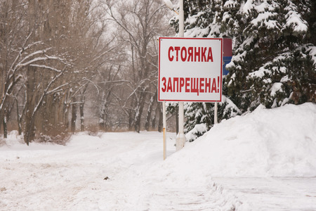 Stand "No parking" at the snow-covered roadの写真素材