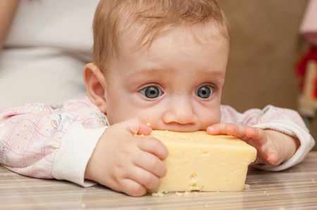 Baby liked a piece of tasty cheeseの写真素材