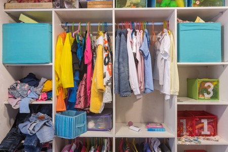Open wardrobe with things and toys in the children's roomの写真素材