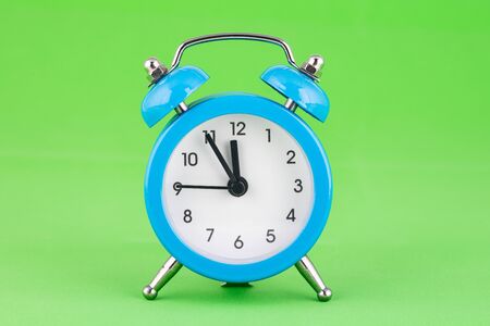 Classic alarm clock on a green backgroundの写真素材