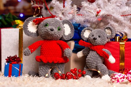 Two homemade plush mice under the Christmas tree with giftsの写真素材