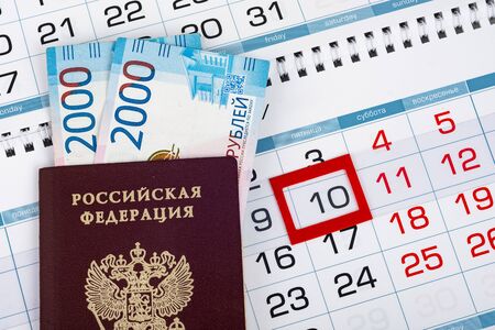 Russian passport with banknotes two thousand rubles are on the calendar with a dedicated date tenth numberの写真素材