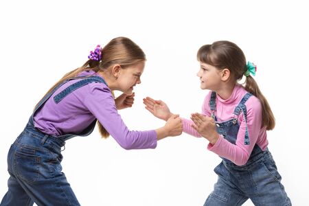 two girls quarrel and fight with each other on a white backgroundの写真素材
