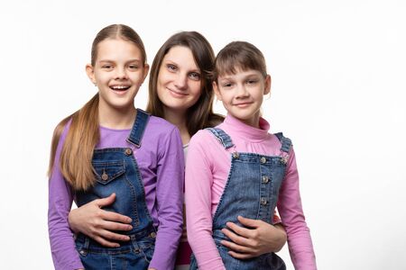 Portrait of a family, mom with two daughters, on a white backgroundの写真素材