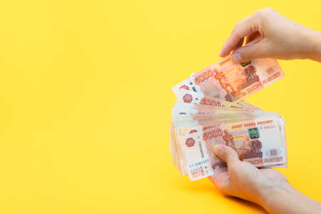 Hands put another bill in a pack of five thousandth billsの写真素材