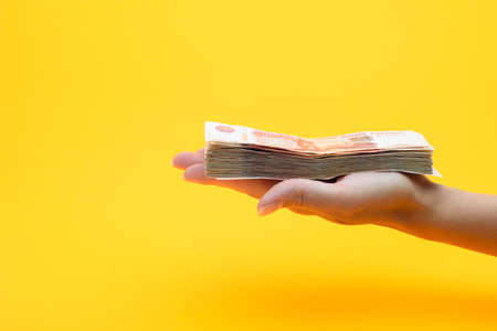 On the palm of his hand is a bundle of five thousandth billsの写真素材