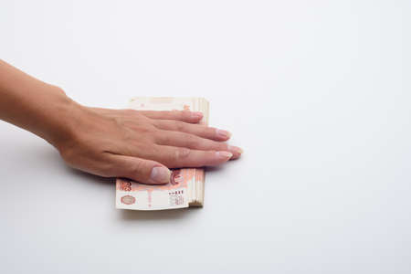 The hand covered a stack of five thousandth bills on topの写真素材