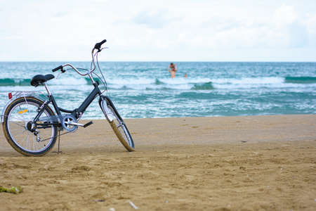The bike stands on the sandy sea beachの写真素材