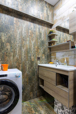 Bathroom interior with beautiful tiles, a view of the washbasin built into the furniture with a...