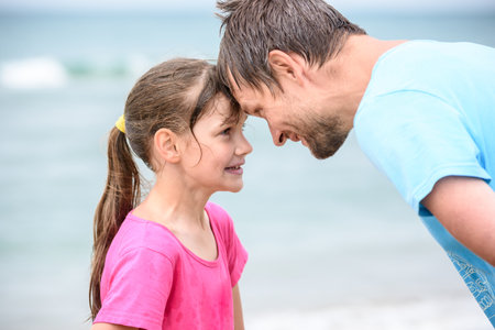 Happy dad and daughter are butting heads cheerfully