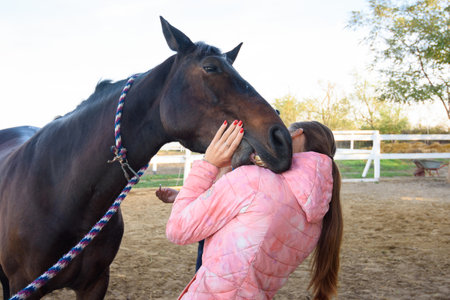 The horse tries to bite the girl on the shoulderの写真素材