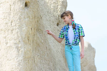 A ten-year-old girl picks a rock with her fingerの写真素材