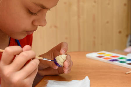 Girl at home paints figures from salt doughの写真素材