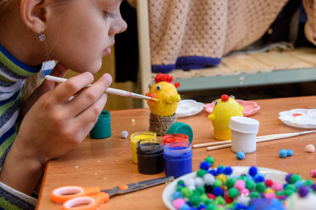 The girl paints crafts from eggs for the Easter holidayの写真素材