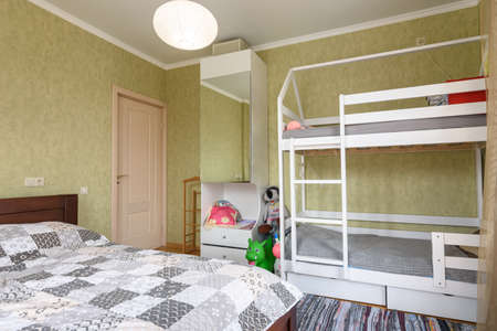 Bedroom interior with a large double bed and a children's bunk bedの写真素材