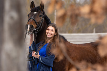 Portrait of a happy beautiful girl of Slavic appearance and a horseの写真素材