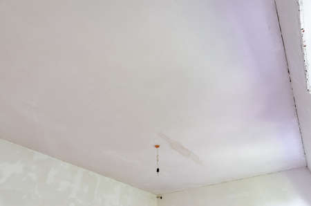 Plastered ceiling in the room, stains from flooding from above are visible on the ceilingの写真素材