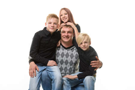 Half-length portrait of a father and three children in casual clothes on a white backgroundの写真素材